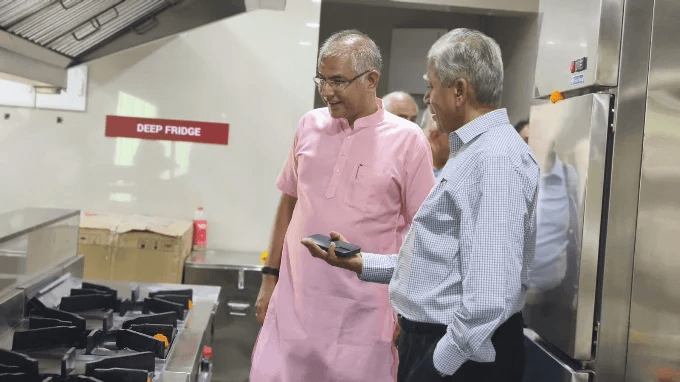 Visitors discussing equipment in a commercial kitchen