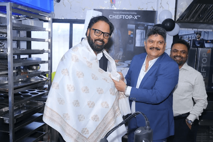 Visitors sharing a celebratory moment beside professional kitchen equipment
